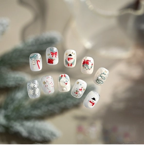 Detail of Christmas nail art stickers featuring 3D embossed snowmen and festive motifs