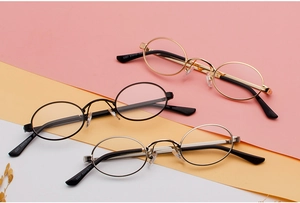 Three pairs of vintage oval sunglasses with gold, black, and silver metal frames