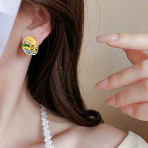 Detail of vintage oval wheat pearl earring with colorful enamel landscape art on model