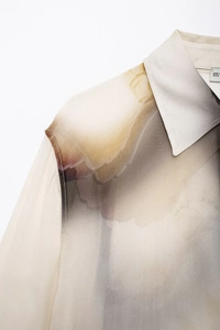 Détail macro d'une chemise en satin avec col et imprimé floral élégant à l'encre délavée