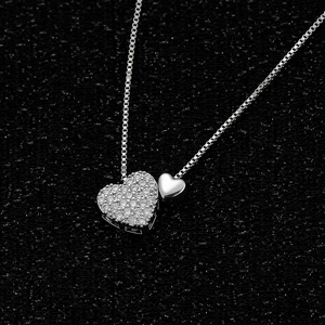 Detailed close-up of double heart pendant necklace with shimmering white cubic zirconia stones