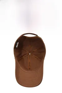 Detail view of the breathable cotton lining and brand logo tapes inside the brown baseball cap