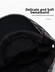 Detailed macro view of the cotton sweatband and plaid wool fabric of the beret cap
