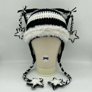 Detail of knit cat ear hat with faux fur trim, star pendants and long tassels
