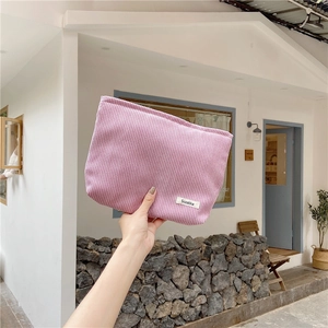 Detailed close-up of pink corduroy texture on a cosmetic bag with a small white label