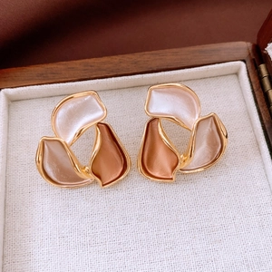 Close-up of abstract flower stud earrings with gold plating in a luxury jewelry box