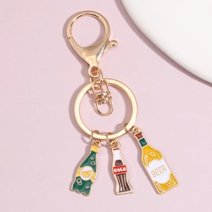 Detail of gold keychain featuring enamel charms for beer, cola, and lemon soda bottles