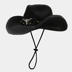 Detailed view of silver bull head metal buckle and gold rivets on black straw cowboy hat