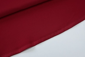Close-up of the fine stitching and hem detail on a wine red backless crop top
