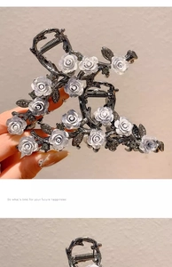 Detail of dark grey metal hair claw clips with white roses and rhinestone embellishments