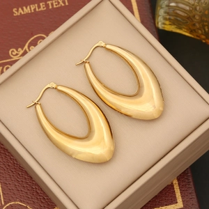 Macro shot of U-shaped gold polished geometric earrings on a luxury jewelry box