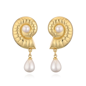 Detail of vintage French gold conch earrings with white pearls and spiral metal textures