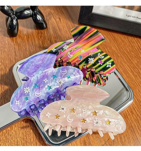 Detailed shot of star and moon hair claws with rhinestones in three elegant colors