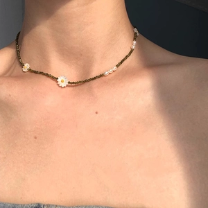 S925 silver necklace with green beads, white pearls, and daisy pendant on model