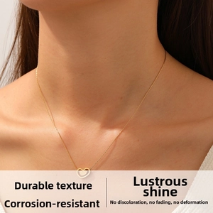 Gros plan d'un collier pendentif double cœur doré sur un modèle aux détails fins