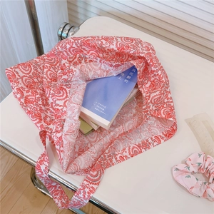 Detailed top view of large capacity floral cotton tote bag filled with lifestyle books