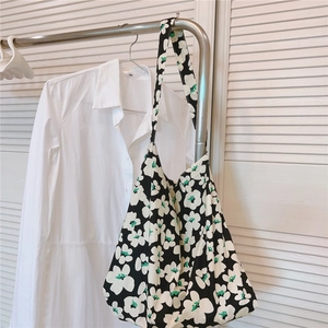 Detail of floral canvas tote bag hanging on a hanger with clean minimalist background