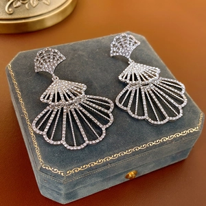 Dettaglio degli orecchini a ventaglio in argento con strass incastonati su velluto blu