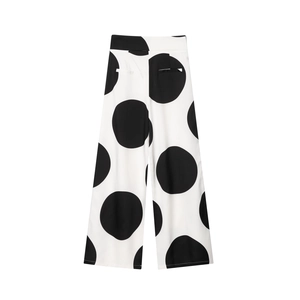 Detalle de pantalones de pierna ancha de talle alto con clásico estampado de lunares blanco y negro