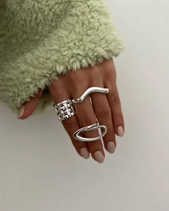 Close-up of three minimalist silver-tone stainless steel rings on a model hand