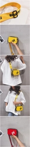 Detail of wide webbed straps with bold lettering on red and yellow mini square bags