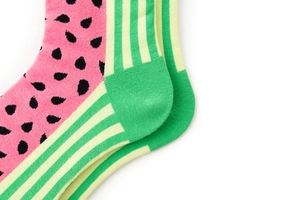 Macro view of watermelon pattern socks with vibrant pink and green fabric texture