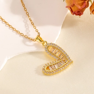 Dettaglio di una collana con ciondolo a cuore dorato con pietre di zircone trasparente lucide
