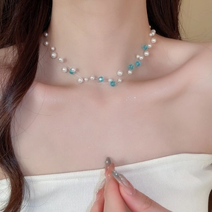Close-up of multilayer pearl and blue crystal bead necklace showing fine texture