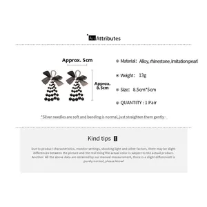 Detail view showing black bow tassel earrings with dimensions of 8.5cm by 5cm