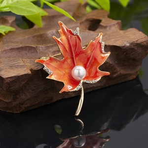 Detailed maple leaf brooch with orange enamel, rhinestones, and center faux pearl