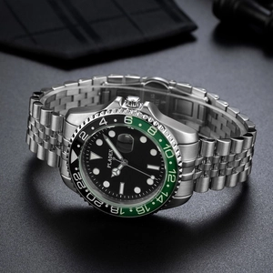 Macro detail of luxury stainless steel watch with two-tone green and black ceramic bezel