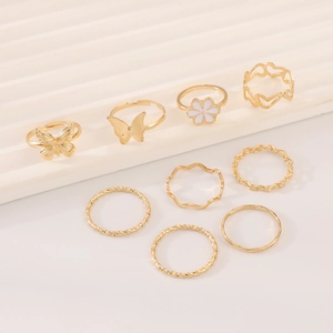 Macro detail of 9-piece gold ring set featuring butterflies and glazed floral designs