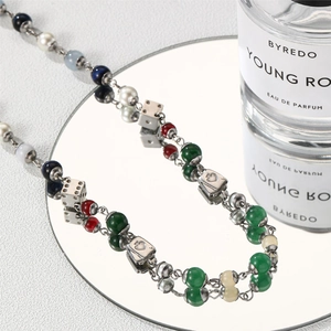 Detailed shot of dice and poker charms beaded necklace reflected on a mirror
