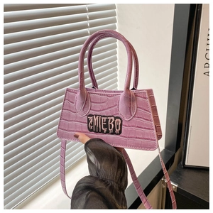 Detail of purple crocodile pattern handbag with ZMIEBO logo patch and twin handles
