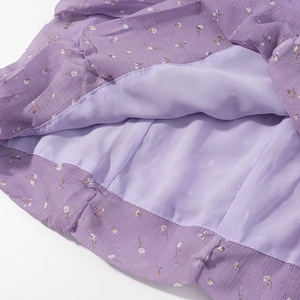 Dettaglio dell'orlo in chiffon floreale viola con tessuto a doppio strato