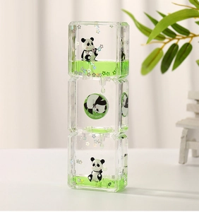 Detail of liquid hourglass with panda figures, green liquid and good luck text