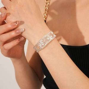 Macro shot of silver-colored hollow lace bangle with butterfly floral pattern on wrist