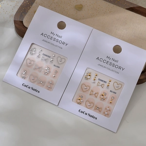 Embossed bow and heart nail stickers with gold and silver accents on elegant mesh backdrop