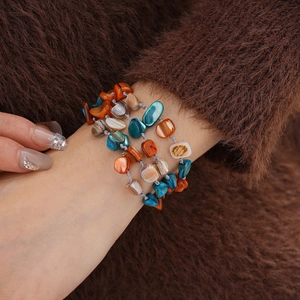 Close-up of multilayered bracelet with colorful irregular shell beads on a model wrist