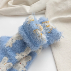 Gros plan sur des chaussettes en molleton corail bleu avec motif de lapin blanc