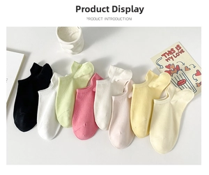 Colorful low-cut cotton ankle socks set arranged in a fan shape on a clean white desk