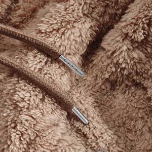 Macro detail of camel lamb wool fabric with thick drawstring and silver metal tips