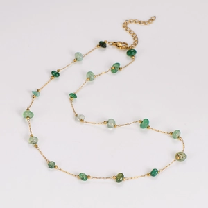Detail of gold chain necklace with irregular green stones and lobster clasp closure