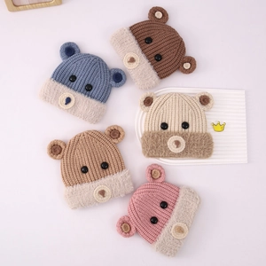 Dettaglio dei cappelli a maglia con orecchie di orso che mostrano la trama della lana