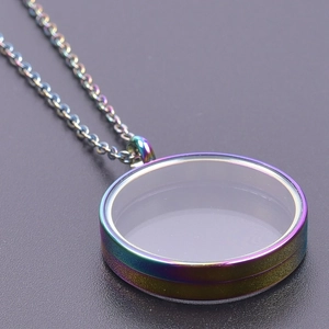 Close-up of rainbow stainless steel round glass locket necklace with white powder filling
