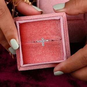 Close-up of a silver cross ring with micro-pave zircons in a velvet gift box