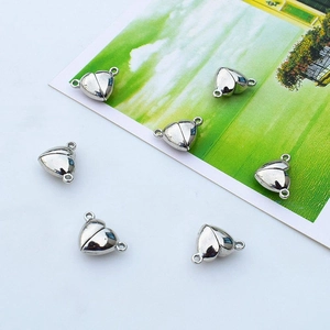 Close-up of heart-shaped magnetic jewelry clasps in polished silver finish for DIY crafts