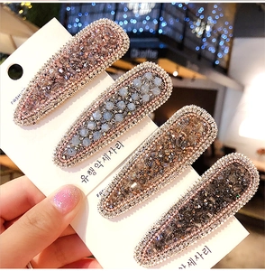 Close-up of four-piece beaded rhinestone hair clips in pastel colors on a display card