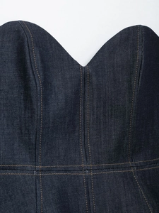 Detailed view of dark blue denim tube top featuring brown contrast stitching and slim fit