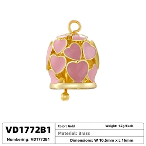 Macro view of a 10.5mm hollow brass heart bell pendant with pink enamel in gold finish